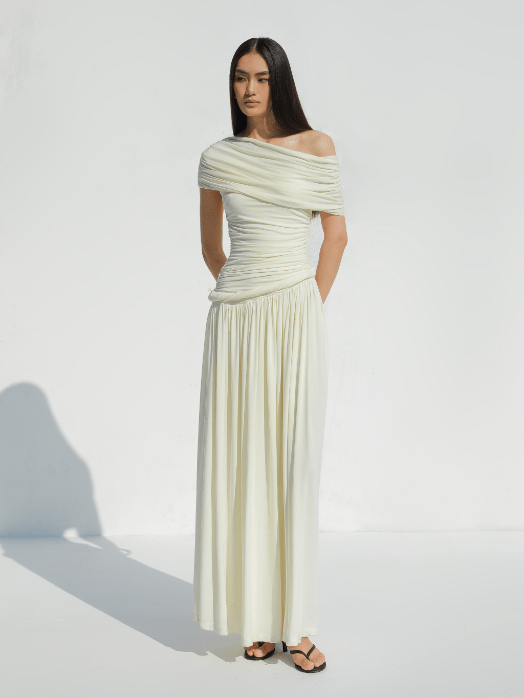 Ivory Off-Shoulder Draped Maxi Dress by COCOSIN